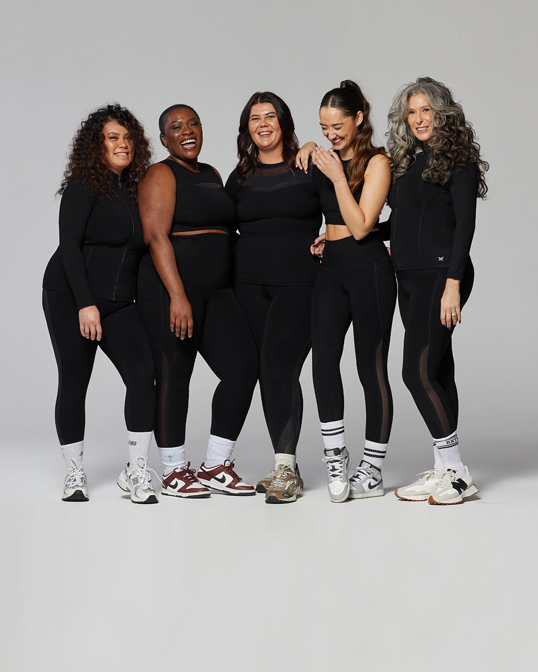 TLC Sport models standing together in black activewear